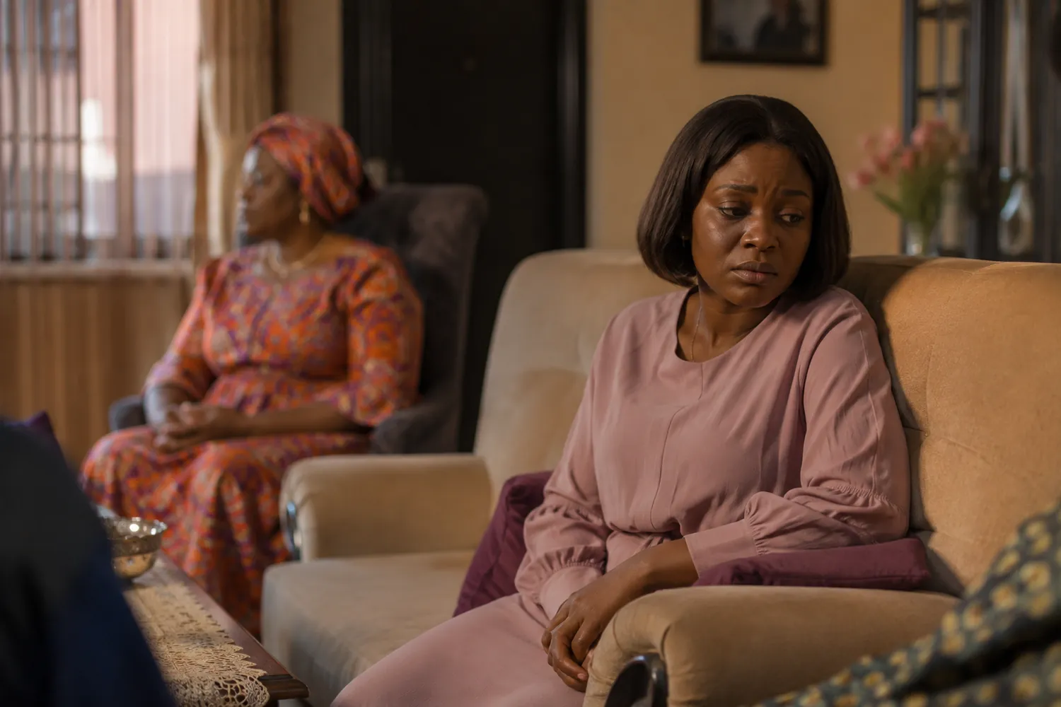 A Nigerian woman sitting apart during a tense family visit